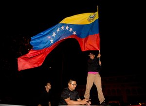 Opposition supporters celebrate in Caracas, Venezuela, early Monday Dec. 7, 2015. Venezuela's opposition won control of the National Assembly by a landslide on Sunday, delivering a major setback to the ruling party and altering the balance of power after 17 years of socialist rule.(AP Photo/Fernando Llano)